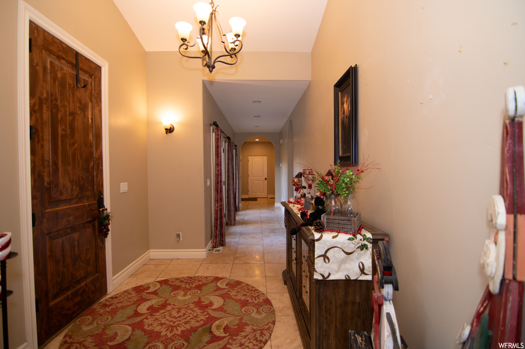 Entrance foyer with a chandelier and light tile floors
