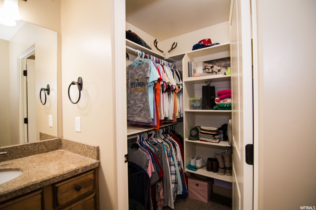 Walk in closet featuring sink and carpet floors