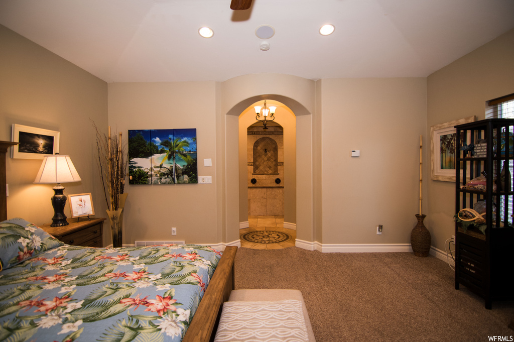 Carpeted bedroom with ceiling fan and ensuite bath
