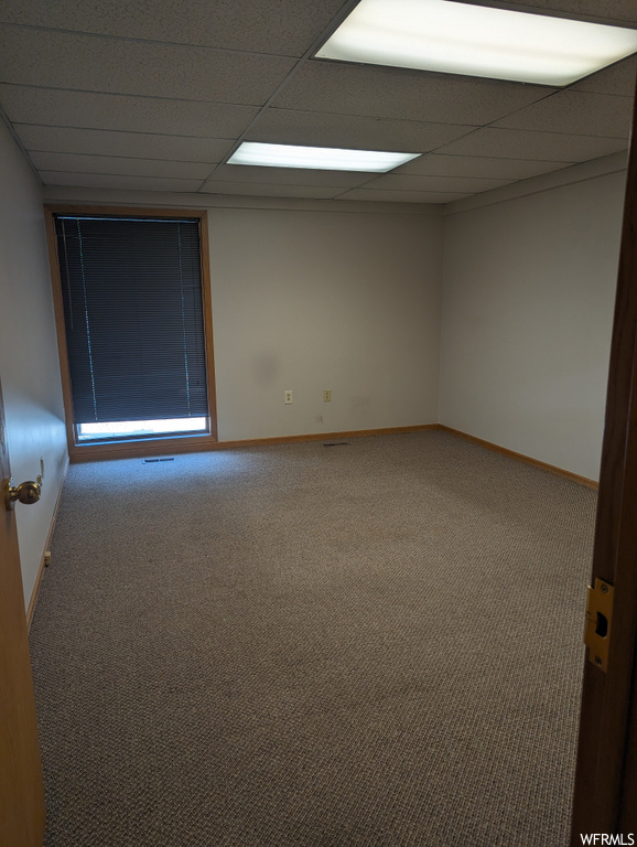 Empty room with a paneled ceiling and carpet