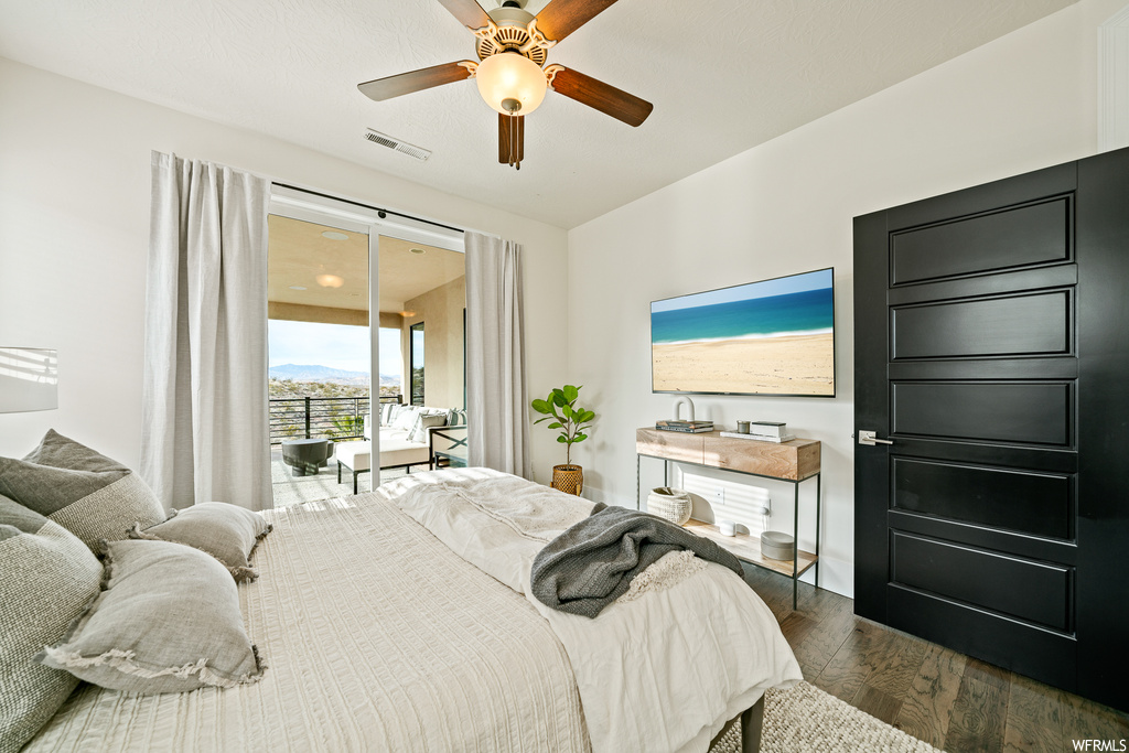 Bedroom featuring dark hardwood / wood-style flooring, ceiling fan, and access to outside