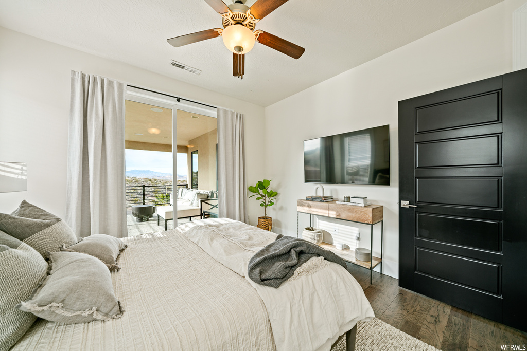 Bedroom featuring dark hardwood / wood-style floors, access to exterior, and ceiling fan