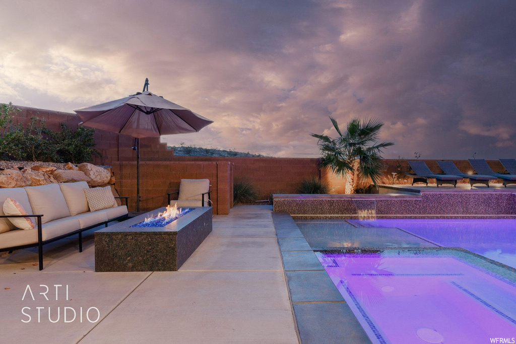Exterior space featuring pool water feature, a fenced in pool, and an outdoor living space with a fire pit