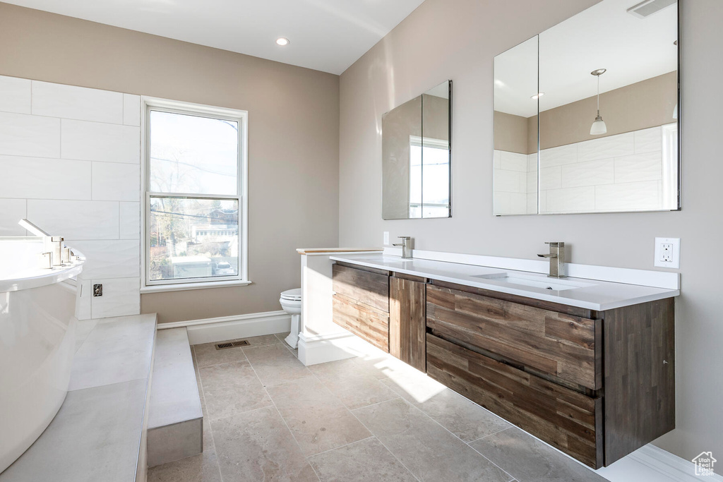 Bathroom with a bath, vanity, and toilet