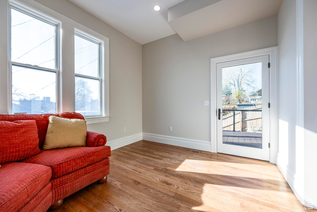 Living room with a wealth of natural light and hardwood / wood-style flooring