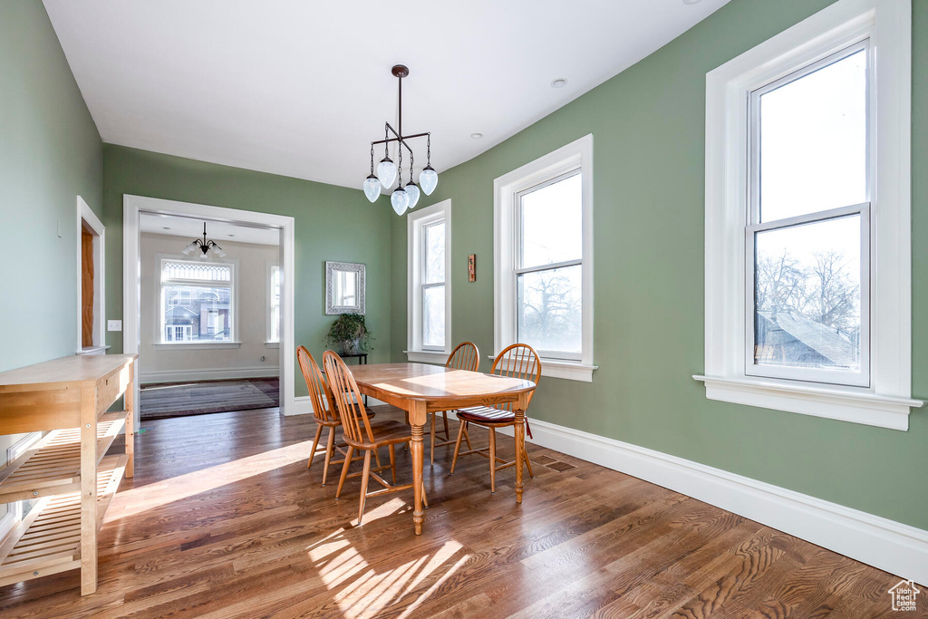 Dining room featuring a notable chandelier and dark wood-type flooring