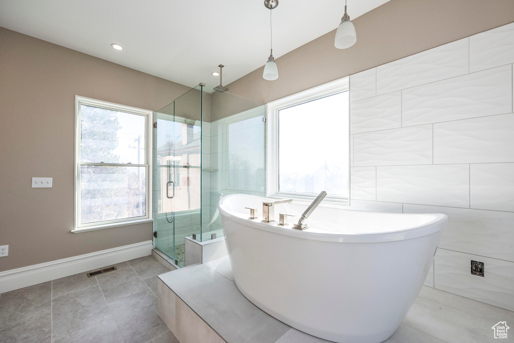 Bathroom featuring independent shower and bath, tile walls, and tile patterned flooring