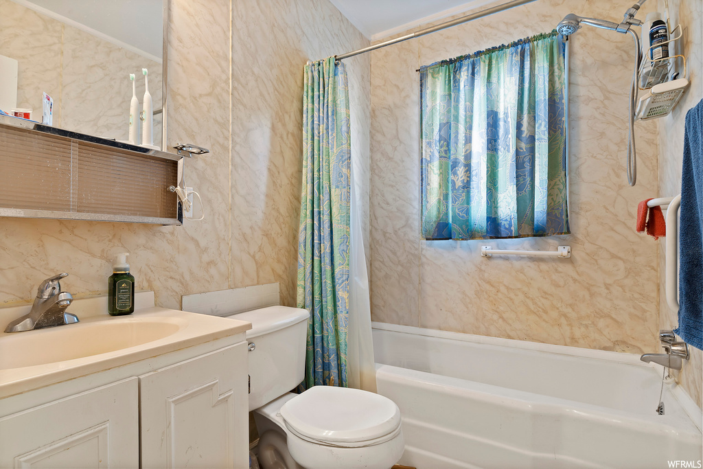 Full bathroom with shower / bathtub combination with curtain, toilet, and large vanity
