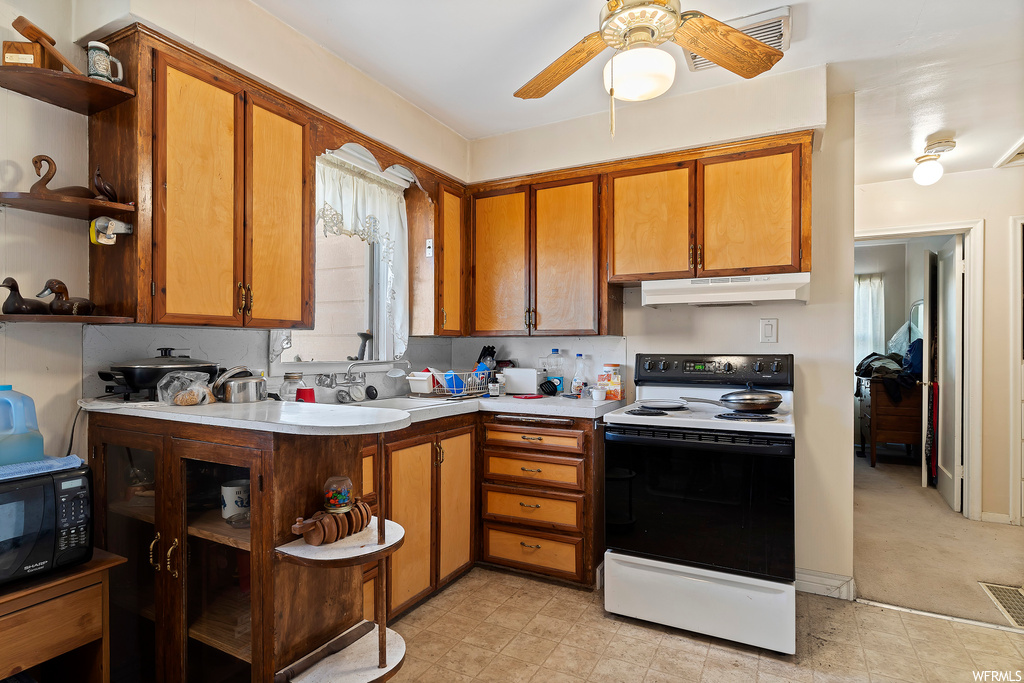 Kitchen with light tile floors, electric range, ceiling fan, and sink