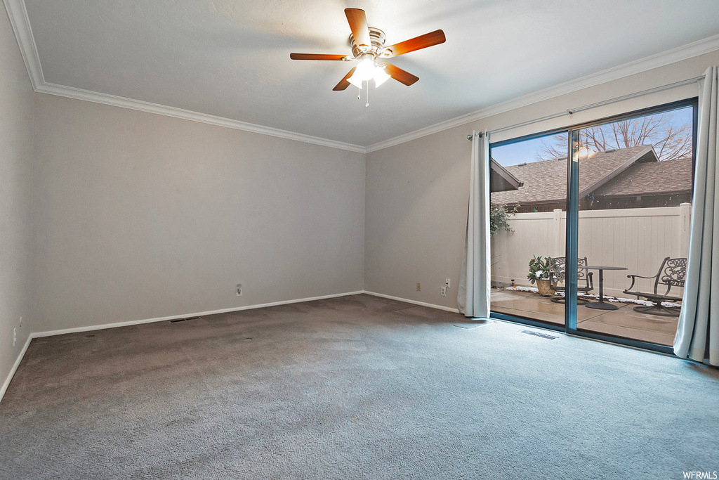 Unfurnished room with dark colored carpet, ceiling fan, and ornamental molding