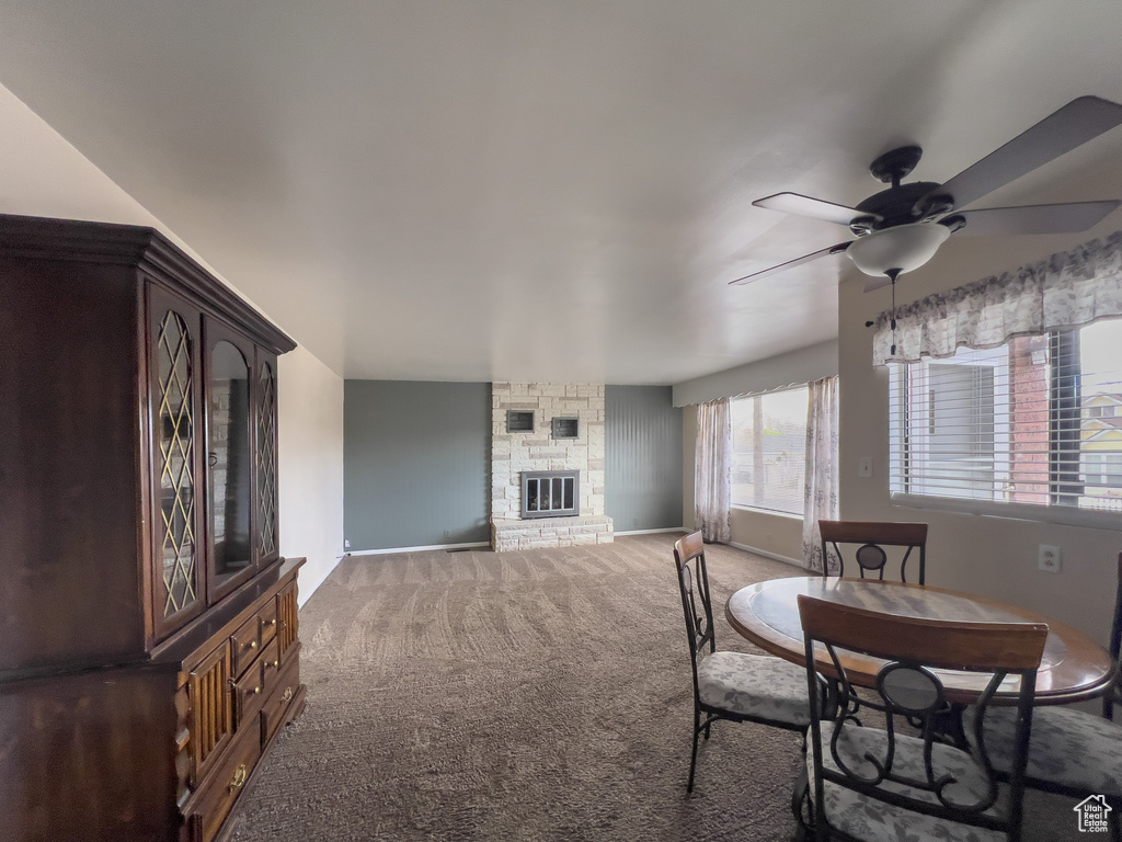 Dining area featuring ceiling fan, a fireplace, and carpet floors