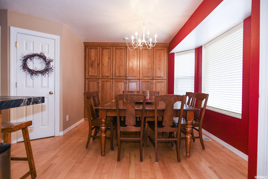 Dining area featuring a notable chandelier and light hardwood / wood-style floors