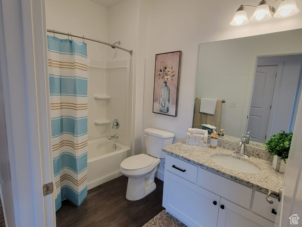 Full bathroom featuring vanity, toilet, shower / tub combo, and hardwood / wood-style floors