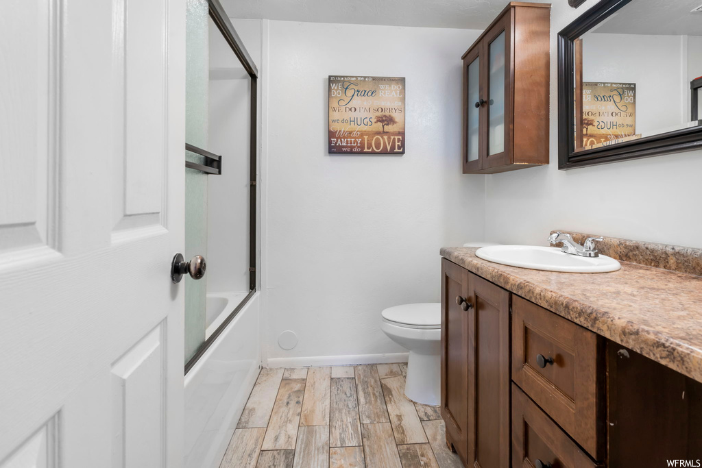 Full bathroom featuring bathing tub / shower combination, vanity, toilet, and hardwood / wood-style floors