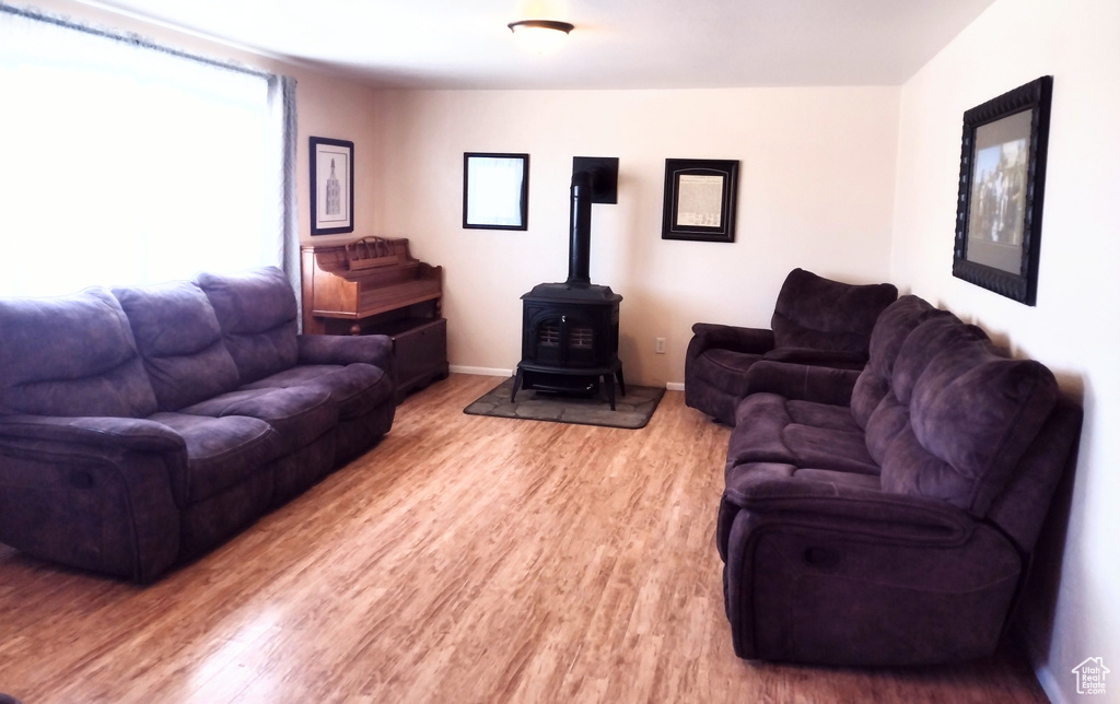 Living room with light hardwood / wood-style floors and a wood stove
