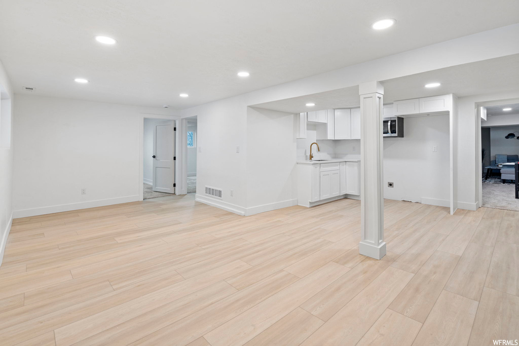 Basement featuring sink and light hardwood / wood-style floors