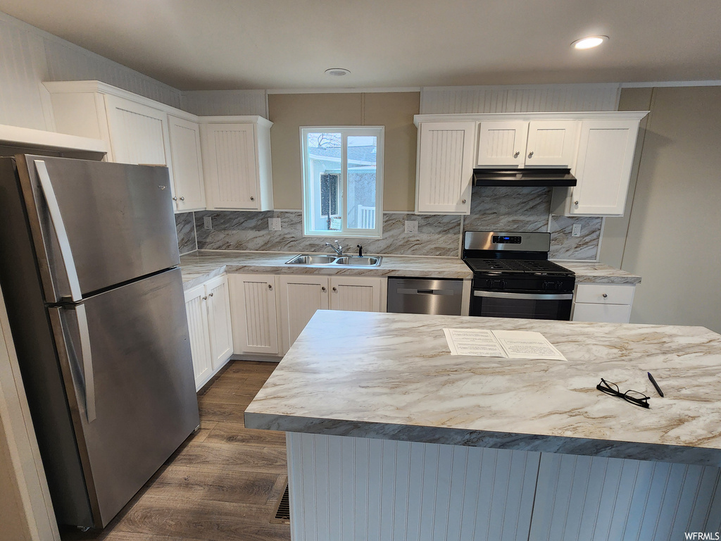 Kitchen with white cabinets, sink, dark wood-type flooring, and stainless steel appliances