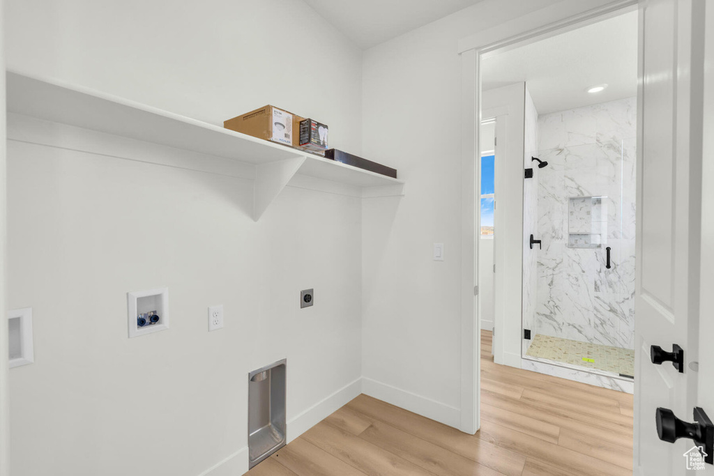 Laundry area featuring hookup for a washing machine, hardwood / wood-style floors, and electric dryer hookup