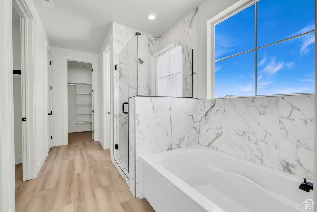 Bathroom featuring hardwood / wood-style floors and separate shower and tub