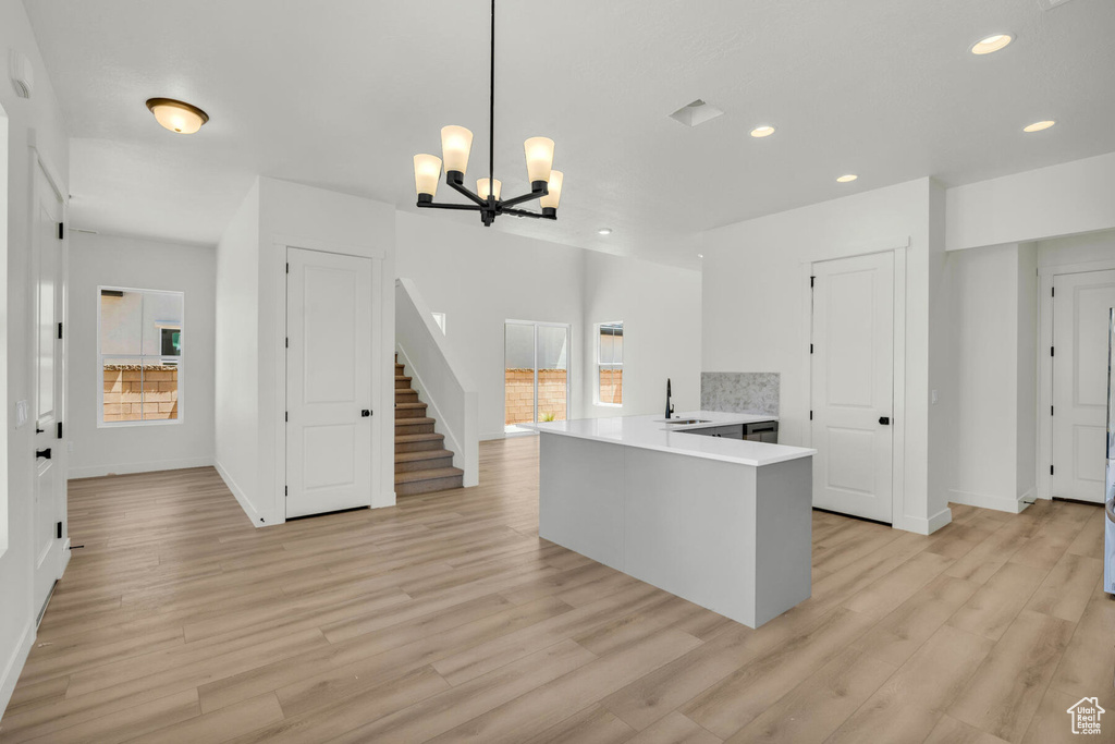 Kitchen featuring an inviting chandelier, sink, light hardwood / wood-style flooring, and decorative light fixtures