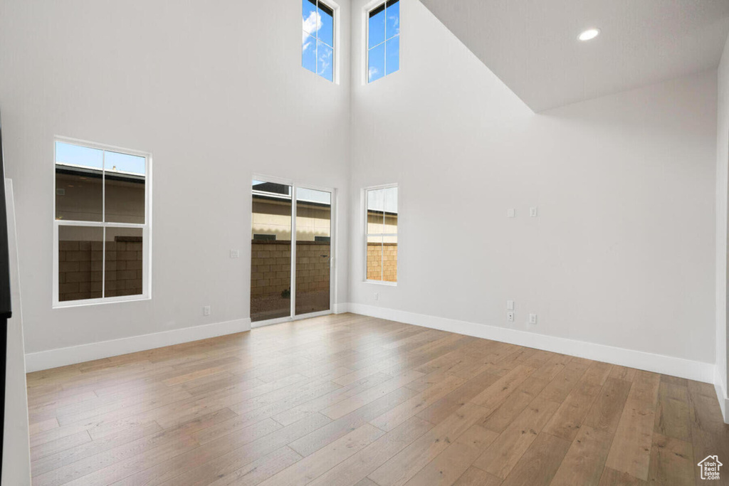 Unfurnished room featuring a towering ceiling and light hardwood / wood-style flooring