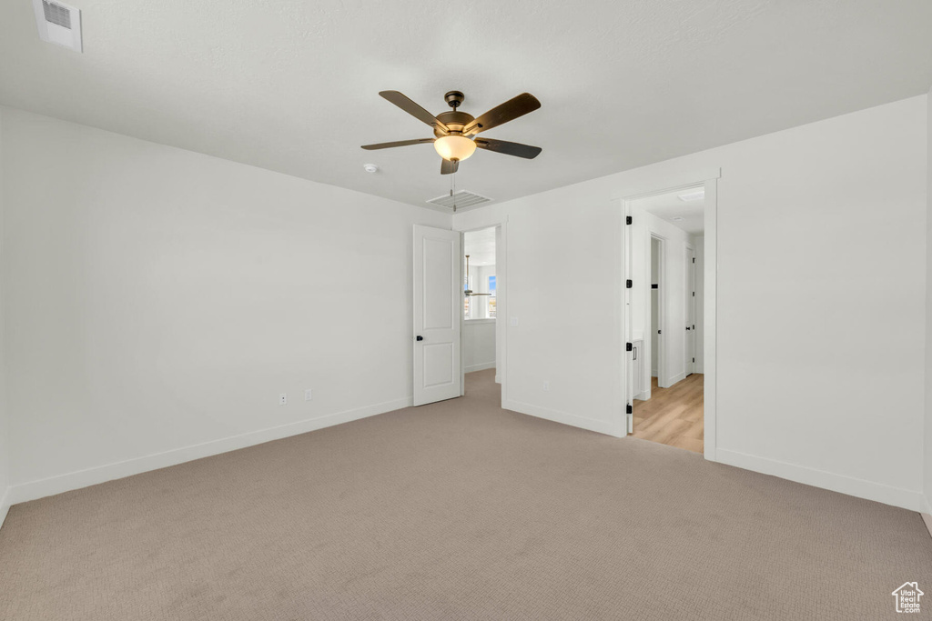 Carpeted spare room with ceiling fan