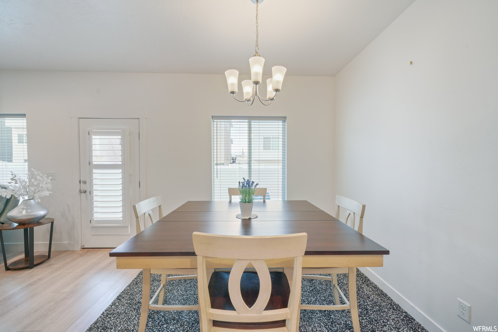 Dining area with light hardwood / wood-style flooring and a chandelier