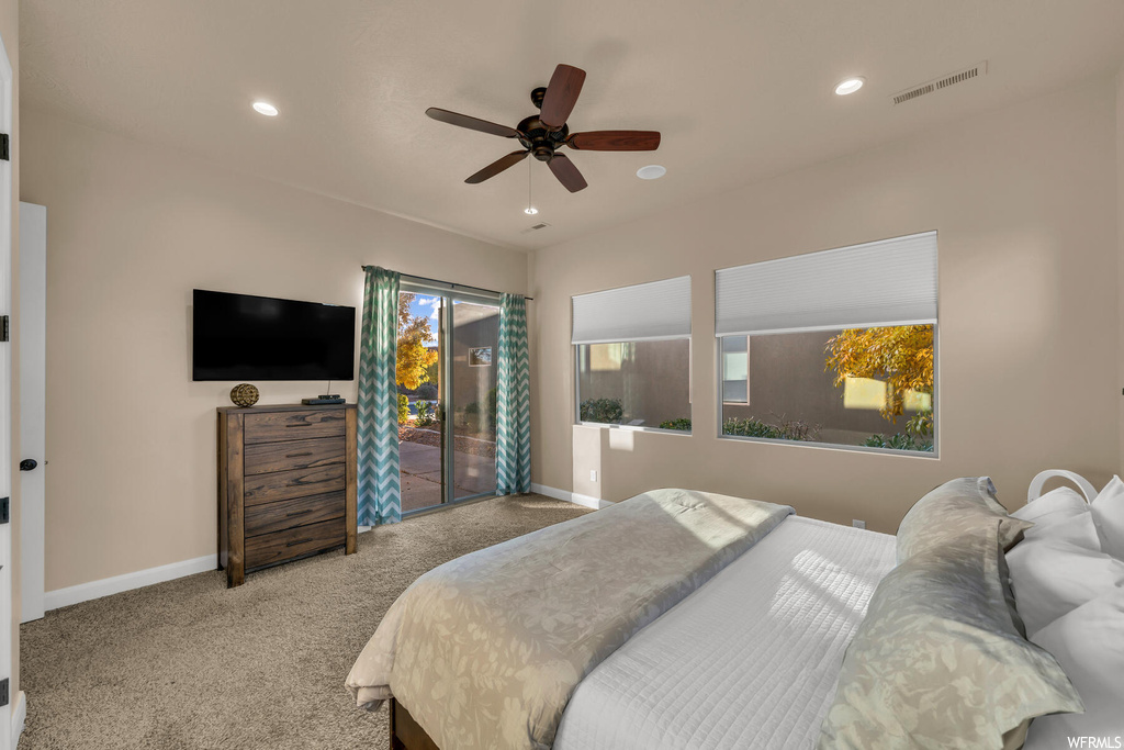 Carpeted bedroom with access to exterior and ceiling fan