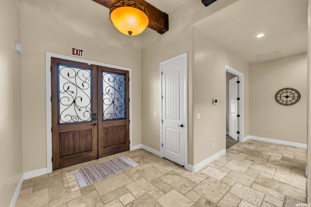 Tiled entryway featuring french doors