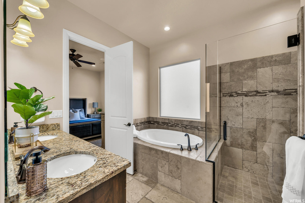 Bathroom featuring shower with separate bathtub, tile floors, ceiling fan, and double vanity