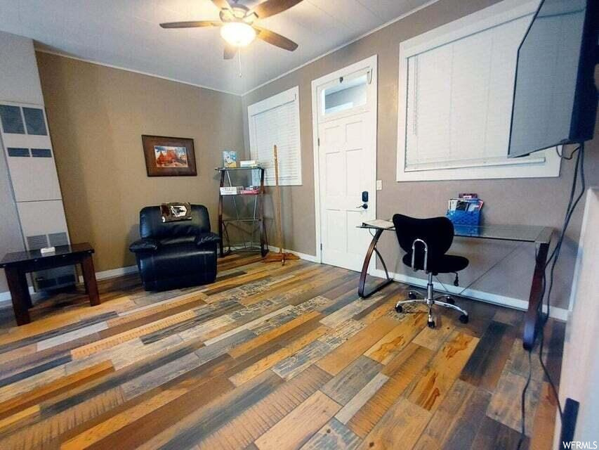 Office with ceiling fan and dark wood-type flooring