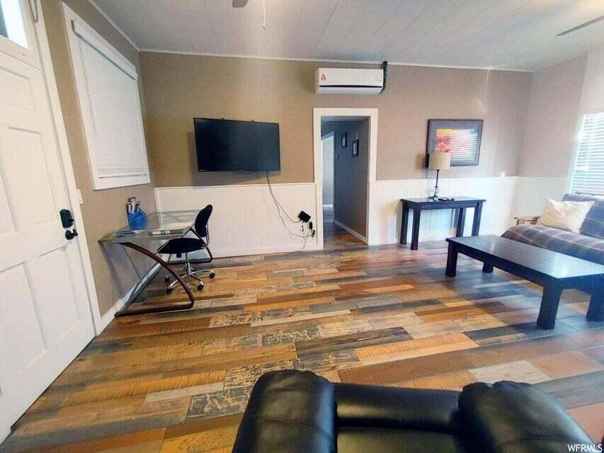 Living room featuring a wall unit AC and hardwood / wood-style floors
