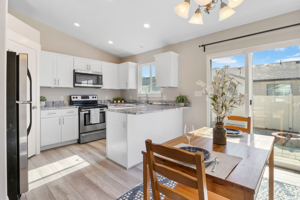 Kitchen with white cabinets, appliances with stainless steel finishes, and plenty of natural light