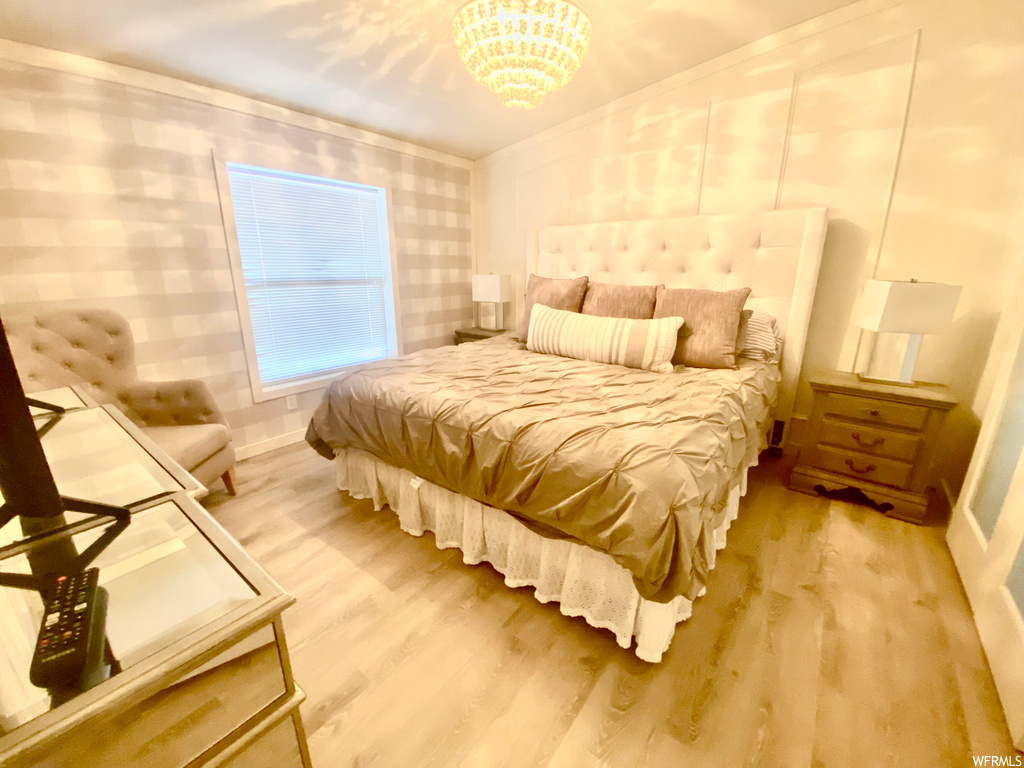Bedroom featuring a notable chandelier and light wood-type flooring