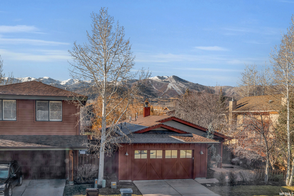 View of front of home with a garage and a mountain view