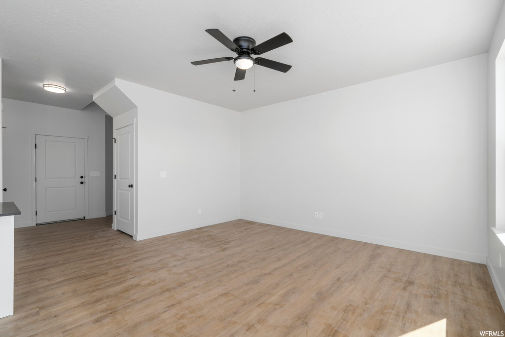 Empty room featuring ceiling fan and light wood-type flooring