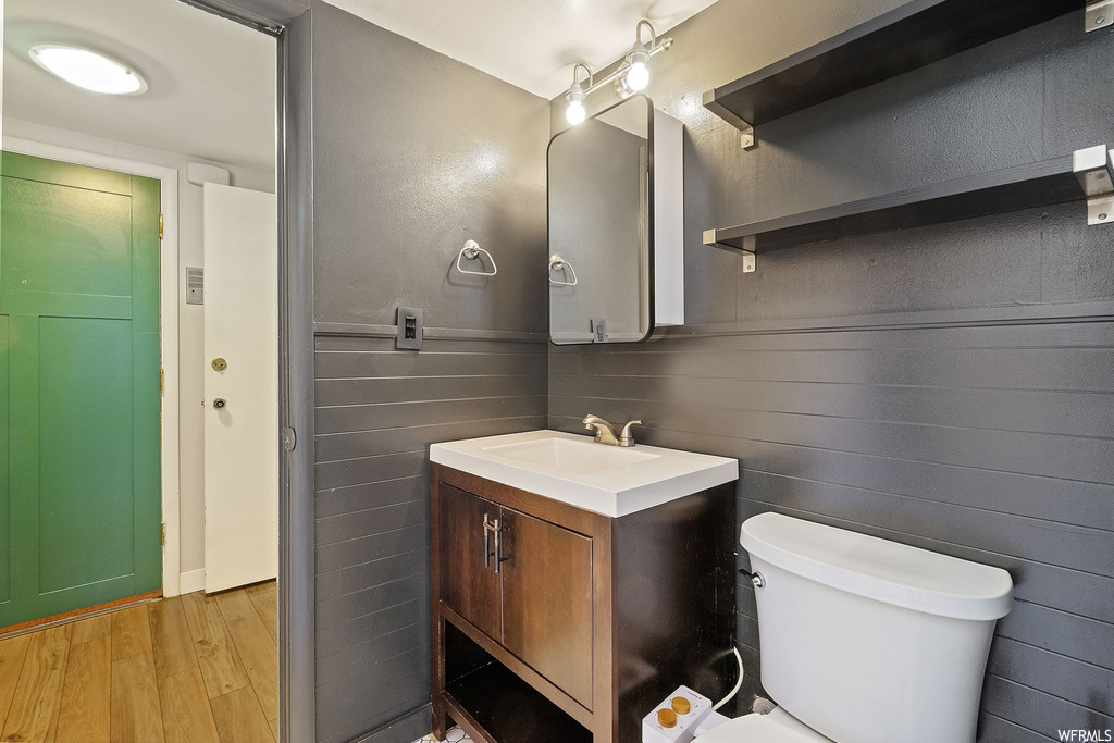 Bathroom with toilet, oversized vanity, and wood-type flooring