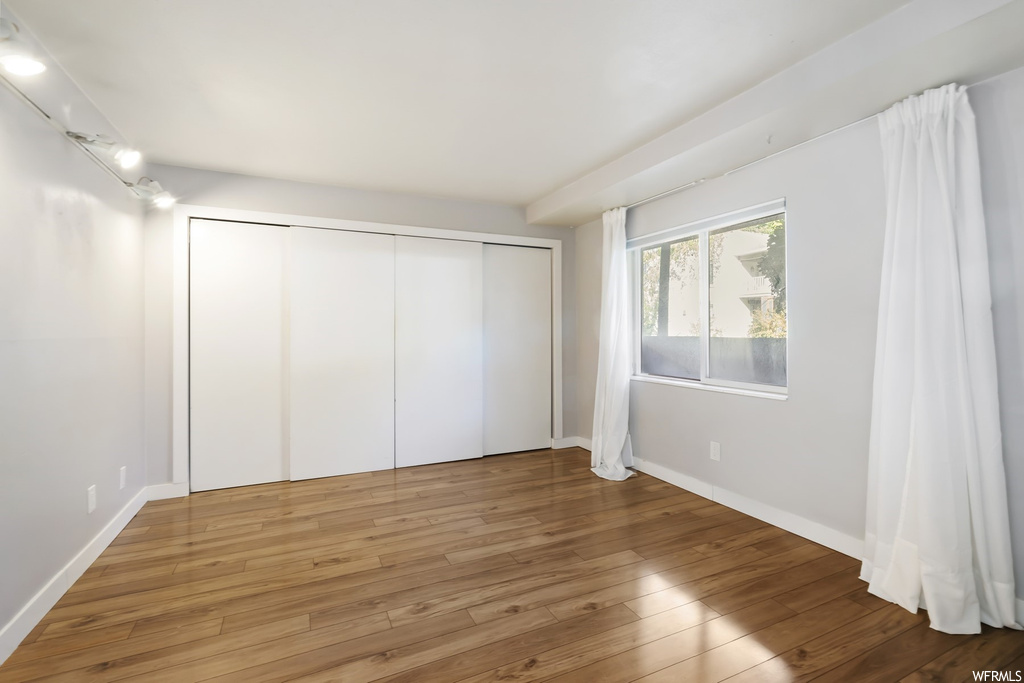 Unfurnished bedroom featuring light wood-type flooring and a closet