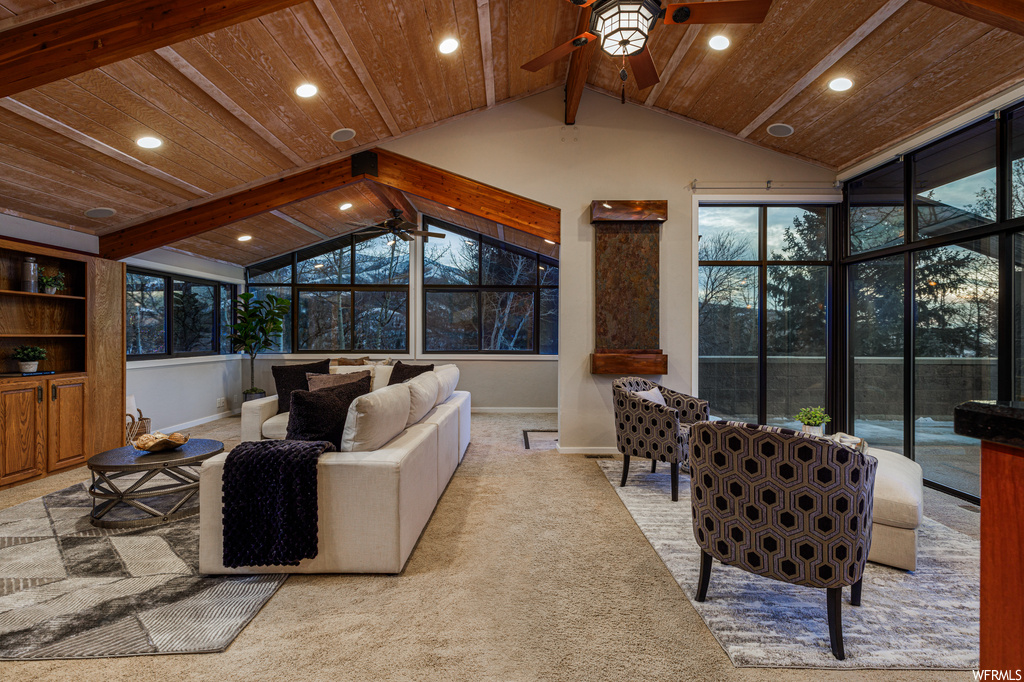 Living room with wood ceiling, ceiling fan, and light carpet