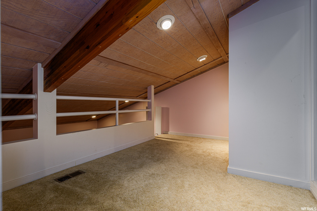Bonus room with light carpet, lofted ceiling with beams, and wood ceiling