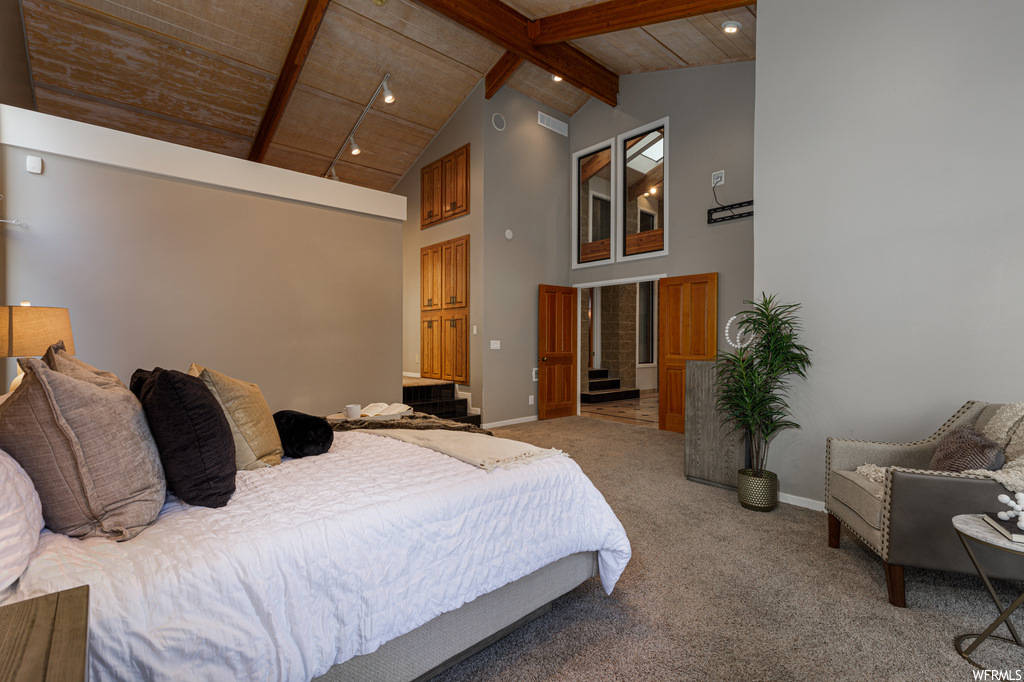 Carpeted bedroom featuring wood ceiling, high vaulted ceiling, and beamed ceiling