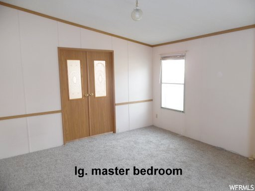 Interior space with crown molding and light colored carpet