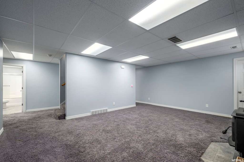 Basement featuring a paneled ceiling and carpet floors