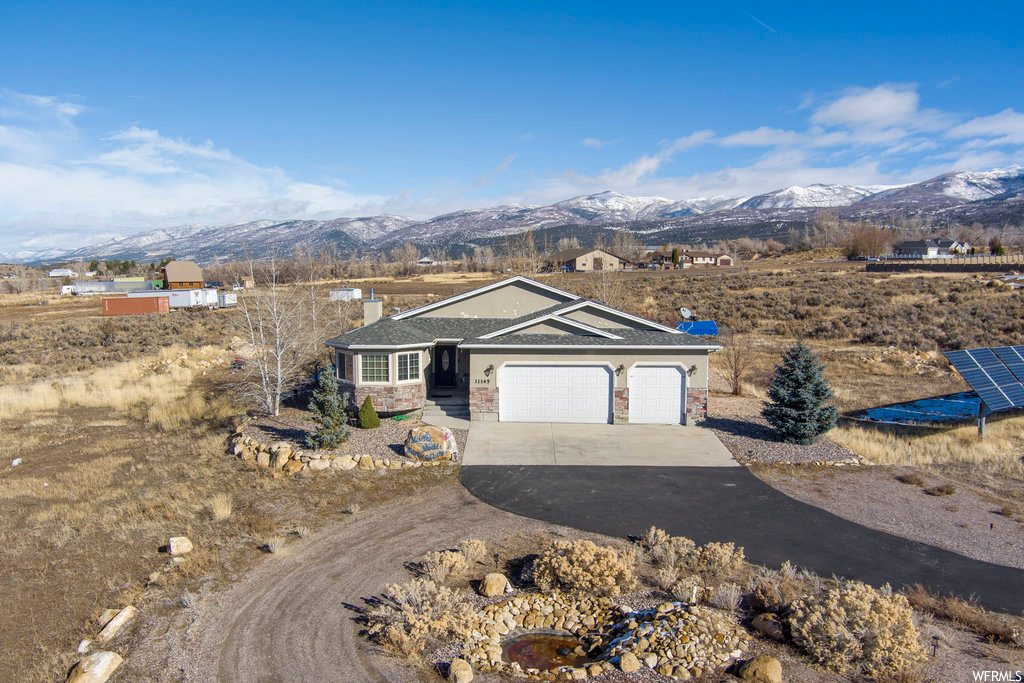 Single story home featuring a garage and a mountain view