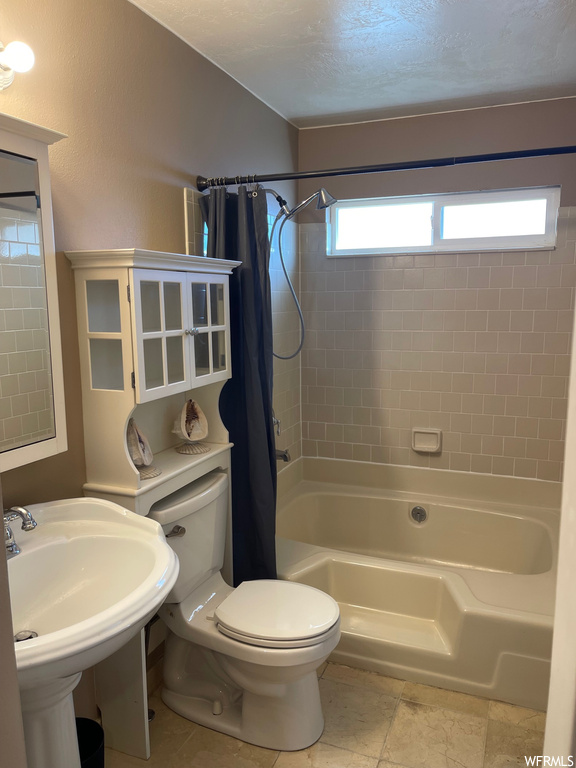 Full bathroom with shower / bathtub combination with curtain, tile flooring, sink, and toilet