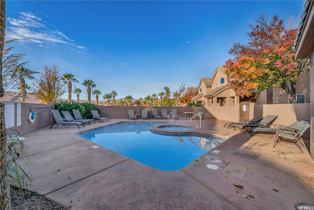 View of pool featuring a community hot tub and a patio