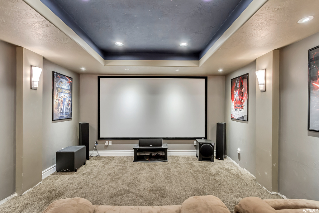 Cinema room featuring a tray ceiling and carpet floors