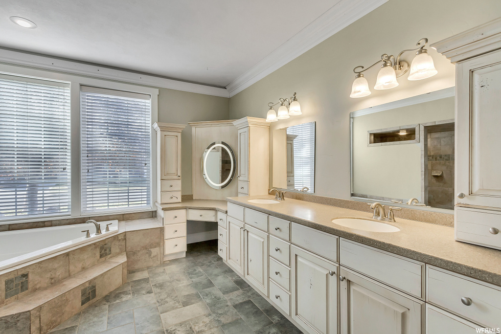 Bathroom featuring dual sinks, a wealth of natural light, large vanity, independent shower and bath, and tile floors