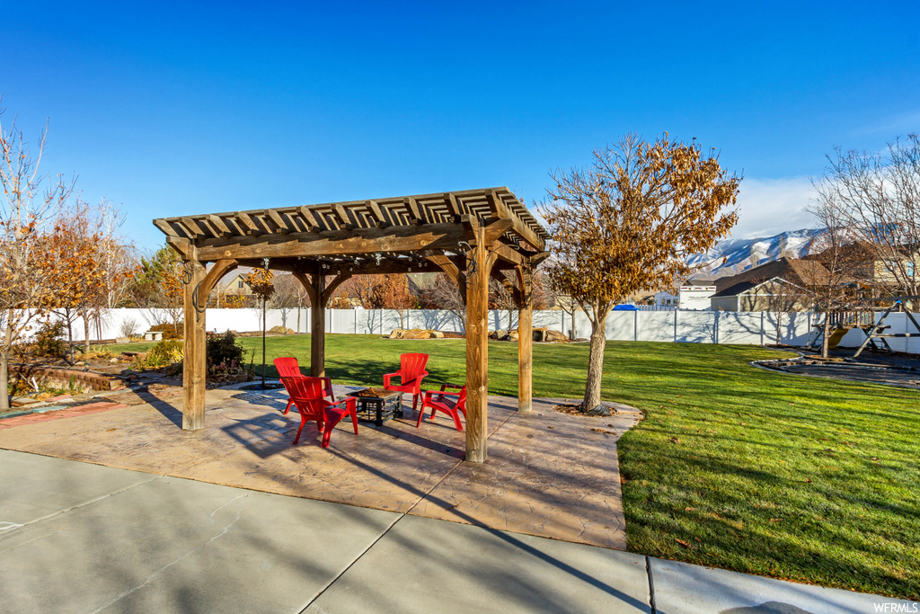 View of property's community with a pergola, a patio, and a lawn