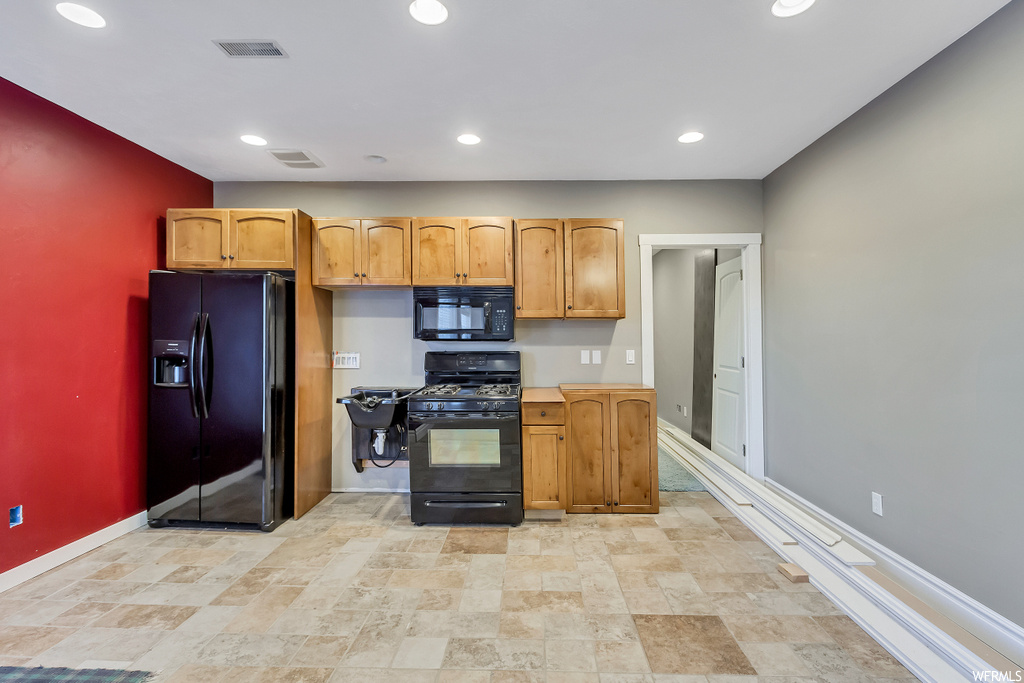 Kitchen featuring light tile flooring and black appliances
